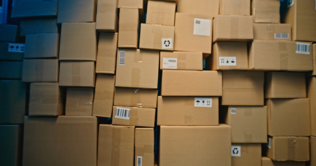 Stacked cardboard boxes in storage representing backlog and inventory bottlenecks