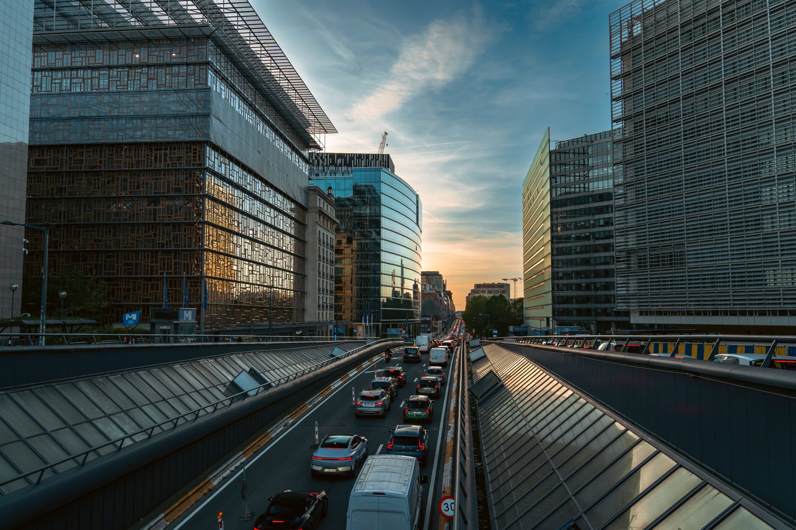 Brussels street lined with modern office buildings at sunset, representing the city's business environment.