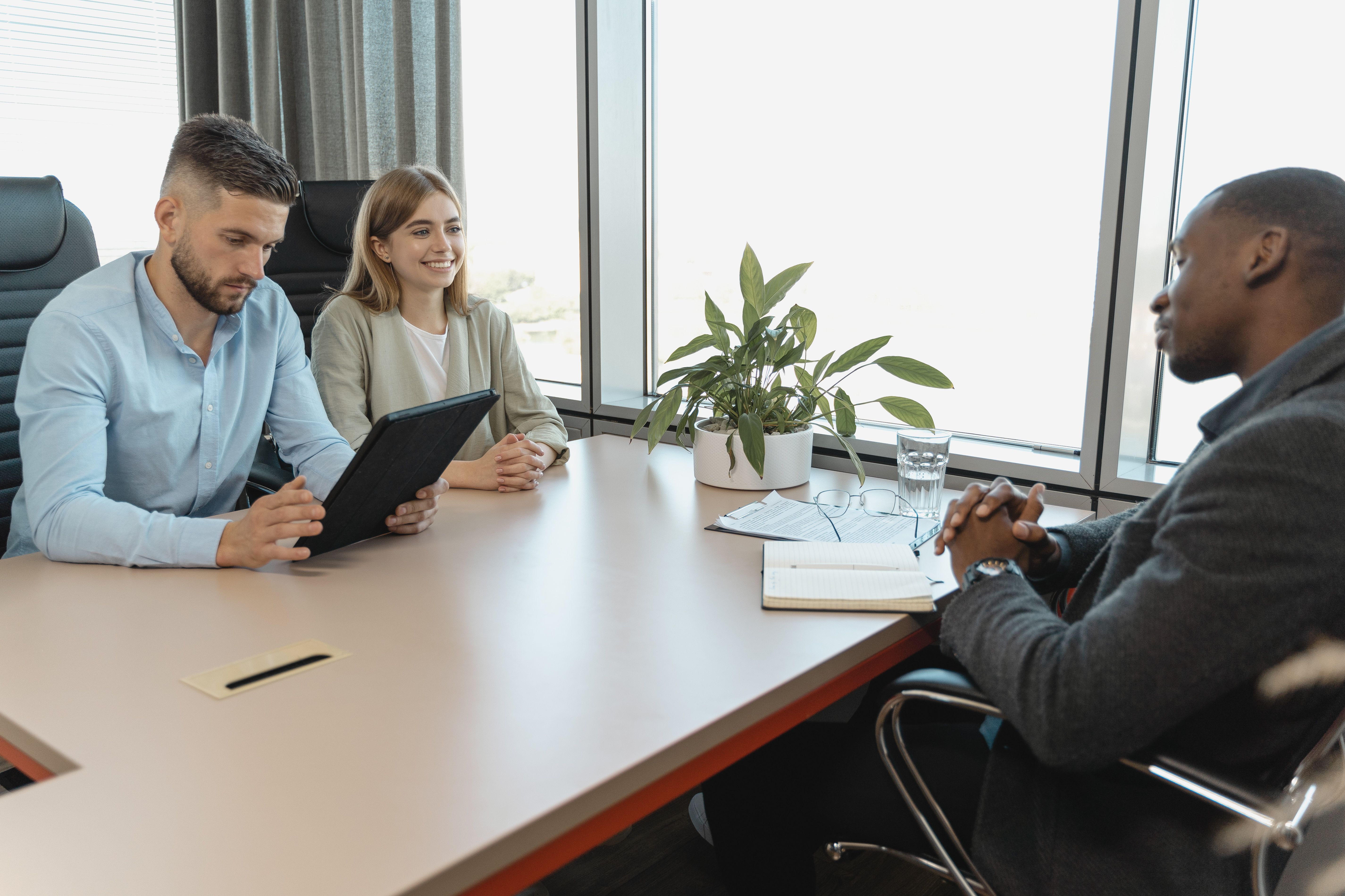Recruiters interviewing a candidate in a modern office, illustrating a structured hiring process.