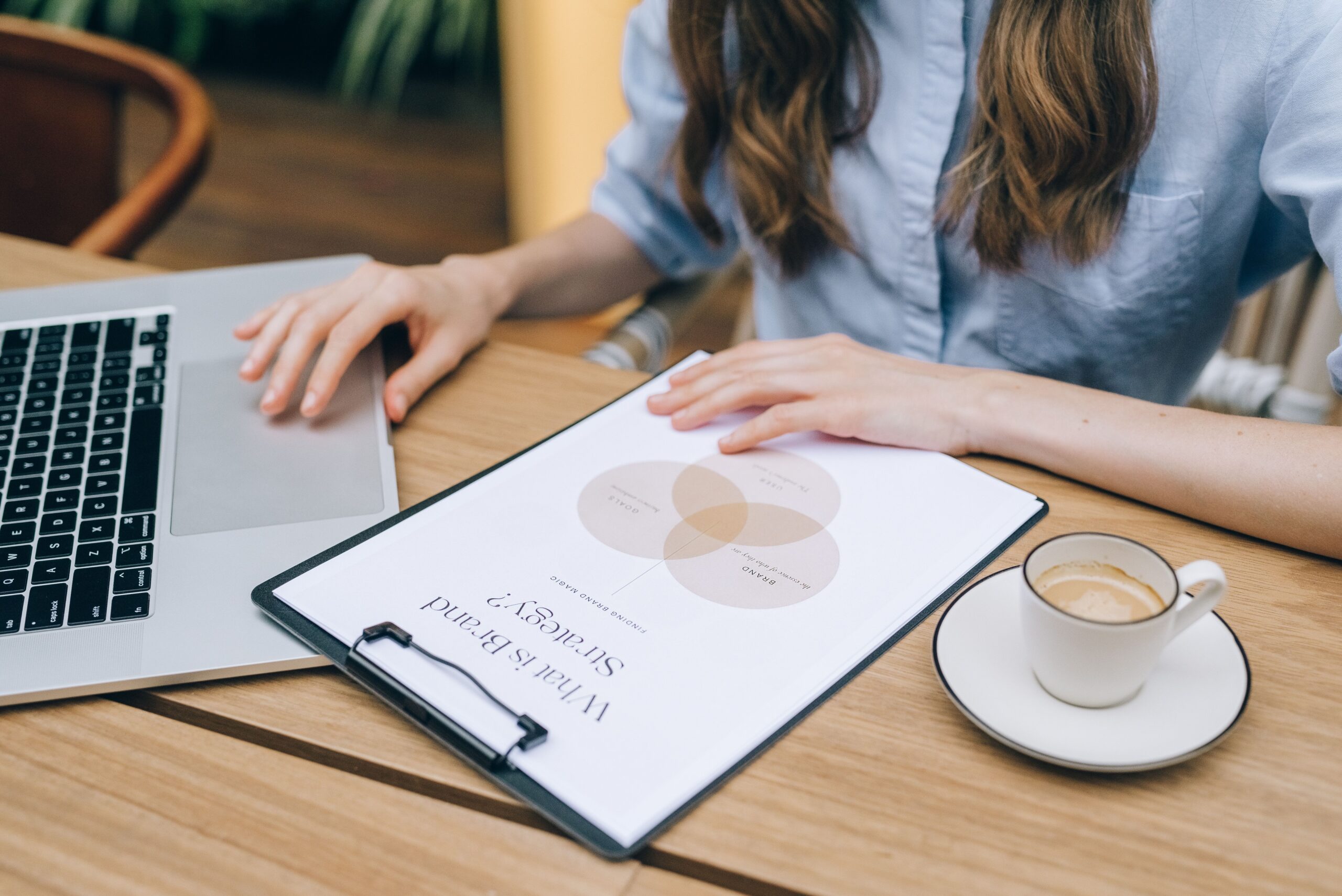 Small-business owner reviewing brand strategy notes beside a laptop at a desk.
